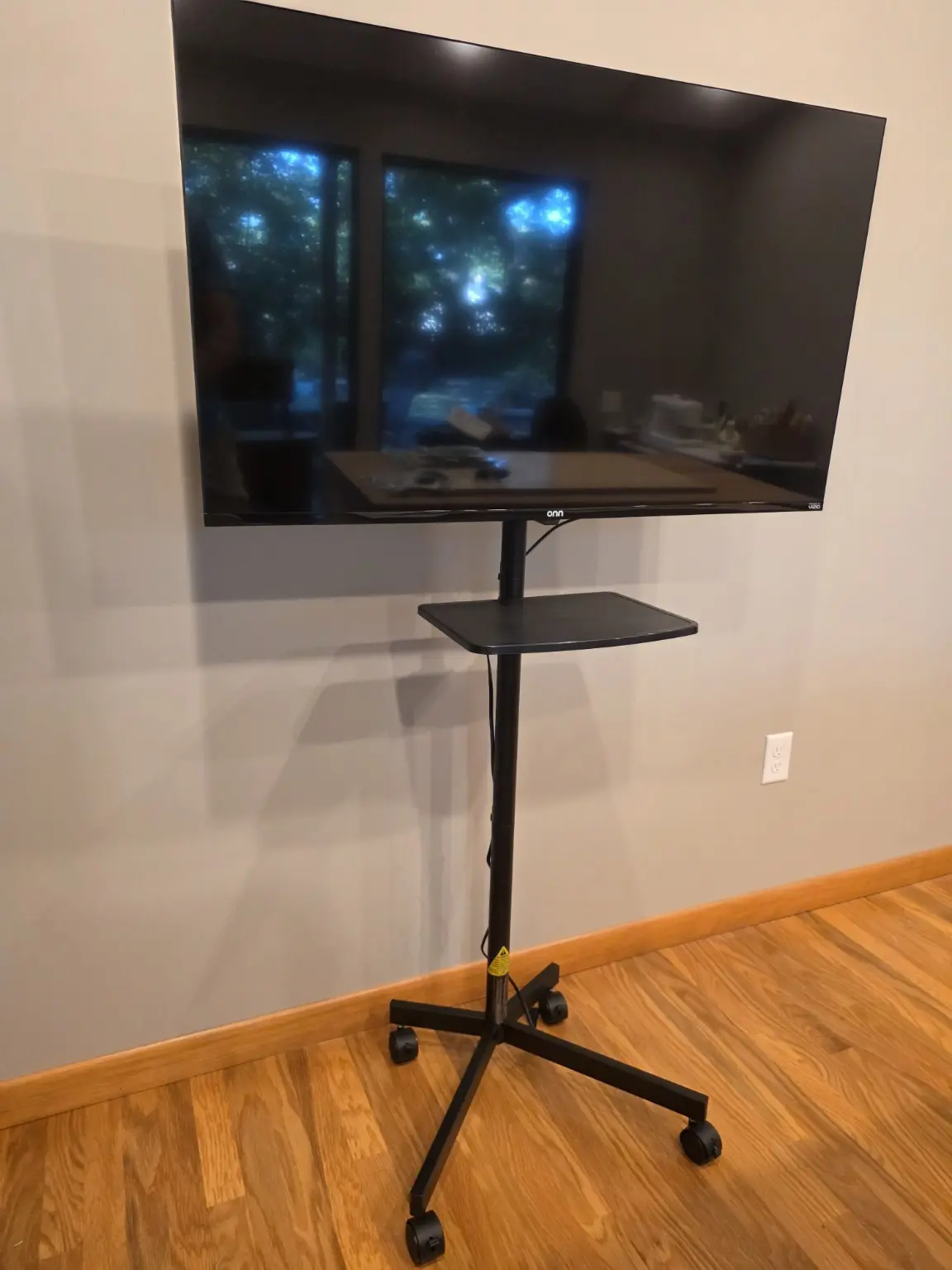 Completed residential rolling TV cart with mounted television and equipment shelf