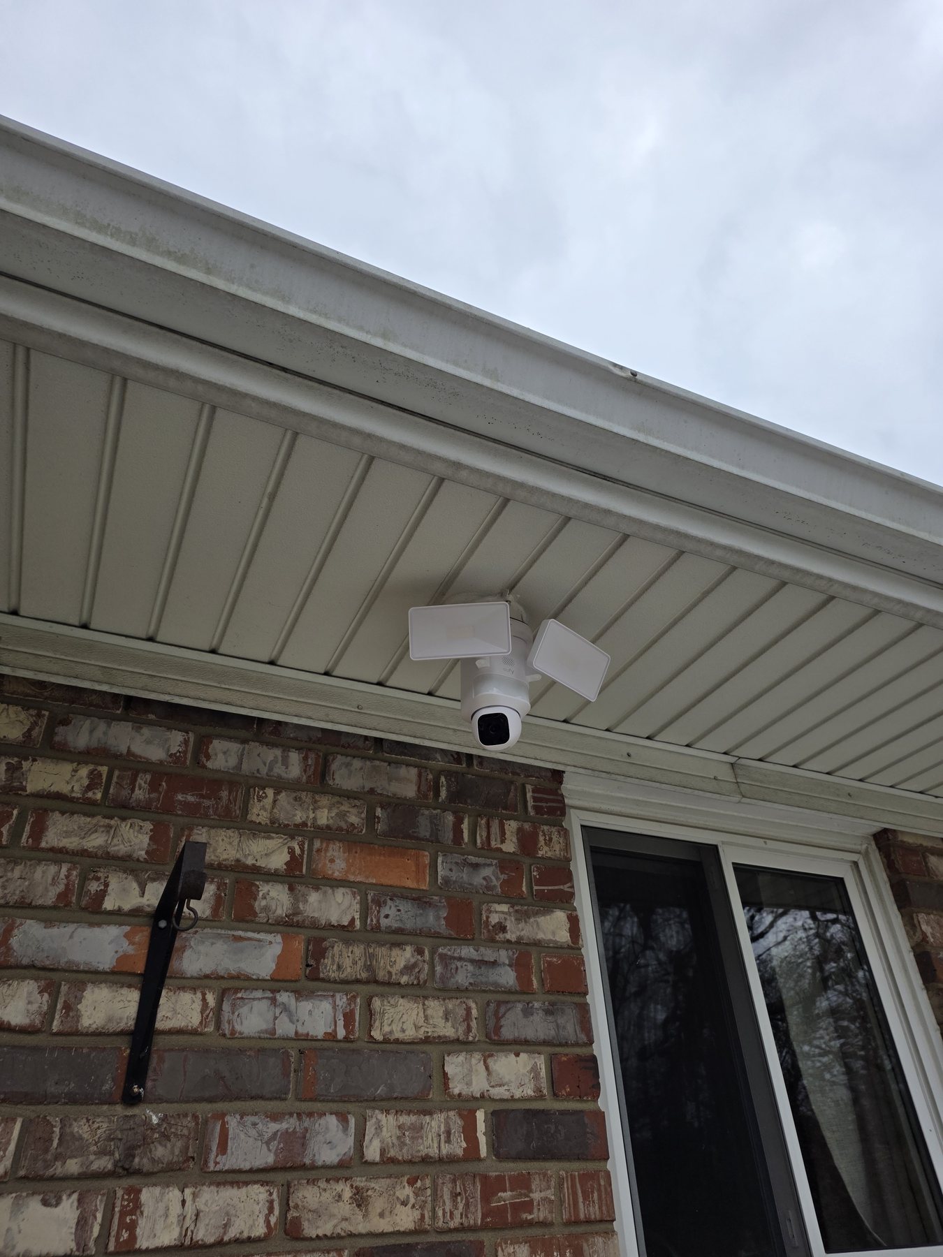 Hardwired Eufy floodlight security camera installed beneath a residential soffit
