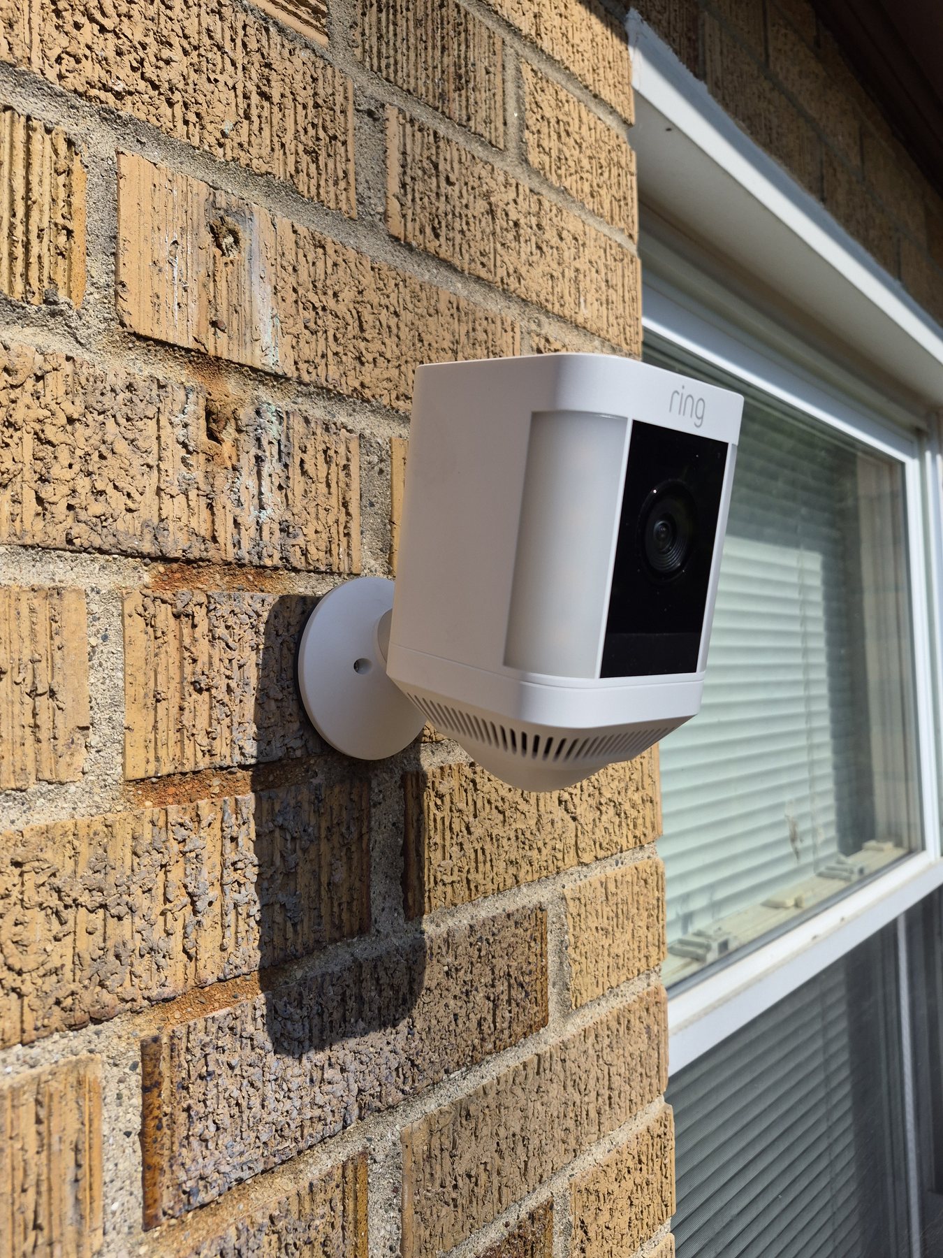 Close-up of an adjustable Ring security camera mount installed on brick