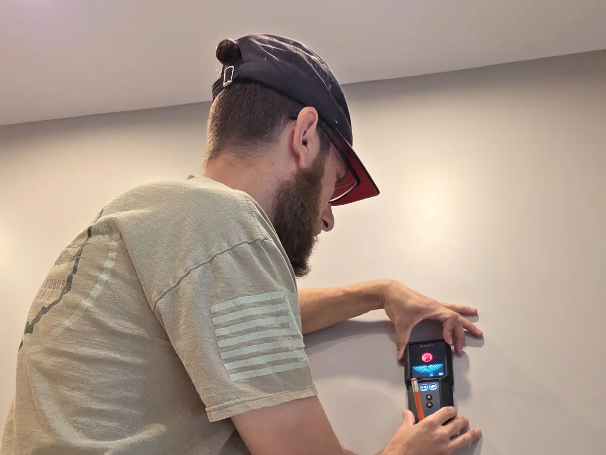 Christopher using a wall scanner during TV-mount preparation